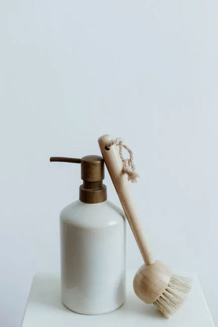 Person using spray bottle and cloth for cleaning a kitchen shelf, ensuring hygiene and cleanliness.